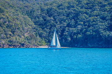 The blue sea and a yacht sailing on Broken Bay