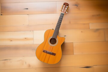 Fototapeta premium overhead shot of acoustic guitar on wooden floor