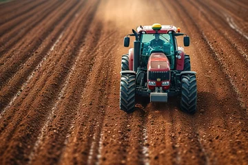 Fotobehang The tractor plowing the fertile soil, preparing it for planting season. © Bargais