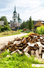 Chopped dry firewood at the countryside against a church - 725440789