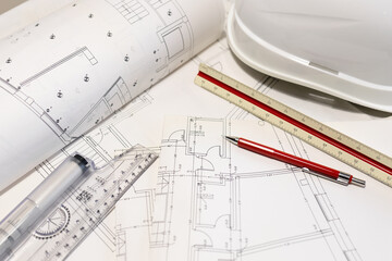 Background of architecture plans, hard hat and architect tools on table