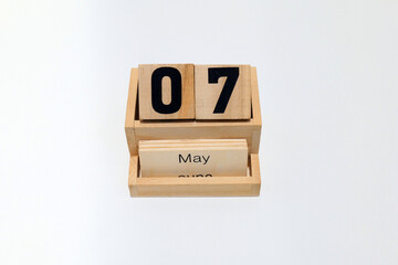 7th of May wooden perpetual calendar. Shot close up isolated on a white background