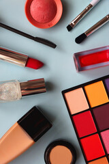 Various colorful make up products on bright blue background. Flat lay.