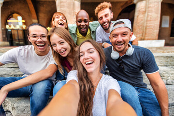 Happy multiracial friends taking selfie pic outdoors - Group of young people smiling together at camera on city street - University students having fun in college campus - Youth community concept - obrazy, fototapety, plakaty