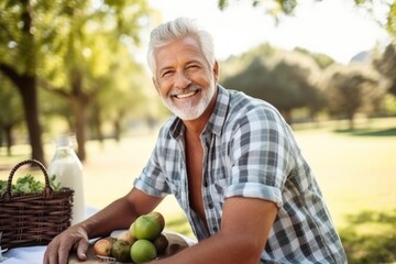 Portrait of a happy senior man having a picnic in the park - Powered by Adobe
