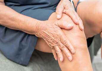 a man sitting and holding his knee in pain