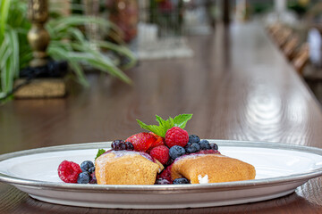 Pancakes with berries on a plate on a table in a restaurant