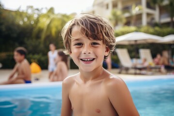 Portrait of a smiling boy in the swimming pool with his friends in the background