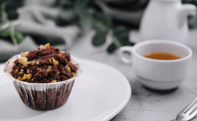 One black chocolate muffins with nuts crumbs