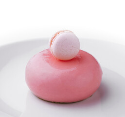 Pink mousse cake decorated with white macaroon