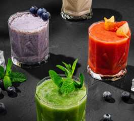 Freshly blended fruit smoothies of various colors and tastes in glass