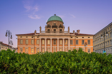 Fototapeta premium Dusk and night in Trieste. Between historic buildings and the sea.