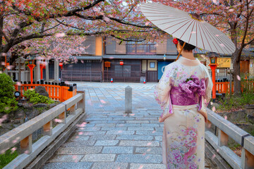 Young Japanese woman in traditional Kimono dress at Tatsumi bashi bridge over Shirakawa river in...