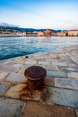 Naklejka premium Dusk and night in Trieste. Between historic buildings and the sea.