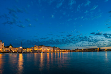 Dusk and night in Trieste. Between historic buildings and the sea. - 725479176