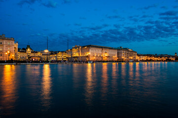 Dusk and night in Trieste. Between historic buildings and the sea. - 725479179