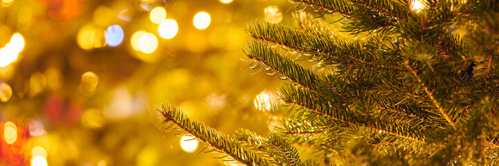 New year christmas tree branch with yellow flickering lights of garlands copy space background,...