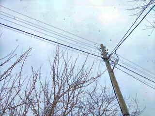 Old pole with wires against the sky. Electric transmission line. Eco-friendly energy