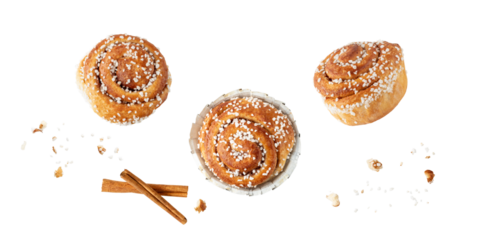 Fresh baked cinnamon buns kanelbulle with crumbs flying falling isolated on white background.