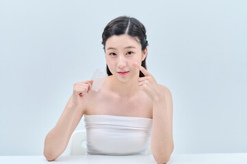 Naklejka premium A clean-skinned Asian girl is making various facial expressions and gestures with a patch that she puts on when her face is scarred.