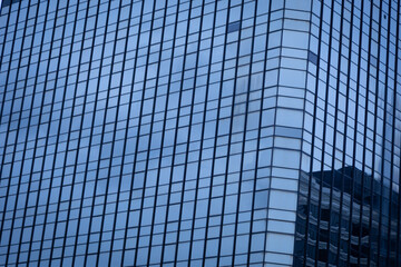 The modern building in the business district has glass windows to let in the light.