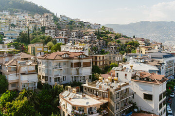Dense residential buildings climb the hillside of a Mediterranean town, showcasing urban life in a scenic setting