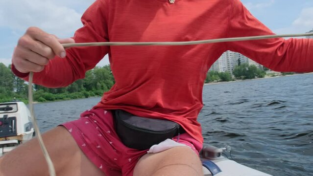 Sailor gradually plays out nylon rope checking necessary lengths before anchoring boat closeup. Preparation process for dropping hook