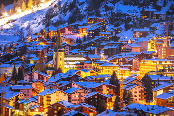 Idyllic village of Zermatt rooftops evening view, luxury winter destination