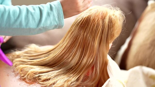 Kid brushing hair of a doll, like a hairdresser. High quality FullHD footage