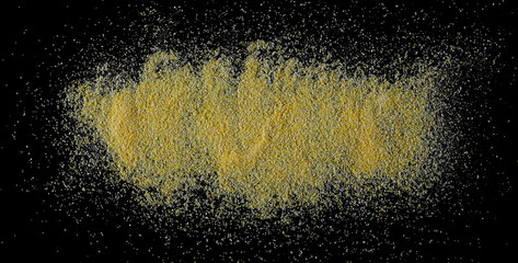 Corn polenta pile isolated on black,  uncooked, top view, clipping path
