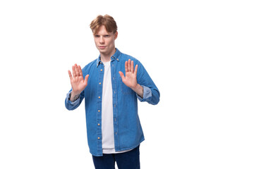 young well-groomed caucasian red-haired man in a denim shirt actively gesticulates