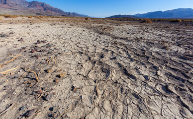 Dry cracked clay in the dry hot stone Mojave Desert in California in Death Valley NP