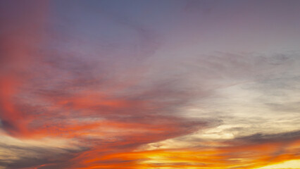Sunset sky background with colourful golden yellow skies in the evening during the sun going down,...