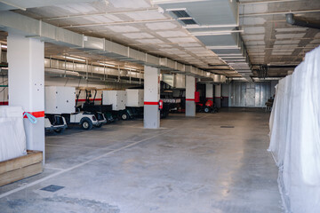 Sotogrante, Spain - January 25, 2024 - parking garage with golf carts and a tractor, concrete...