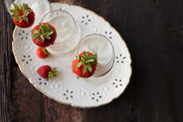 Glass of strawberry cocktail or mocktail, refreshing summer drink with champagne, strawberries, ice cream
