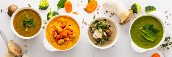 Mushroom and lentil cream soup, beans, carrot and tomato soup, broccoli and spinach soup on white background with cooking ingredients banner