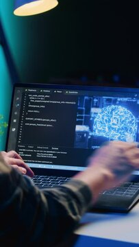 Vertical video Computer scientist updating artificial intelligence machine learning algorithm, writing binary code scripts. Teleworking IT specialist in apartment office uses programming to upgrade AI
