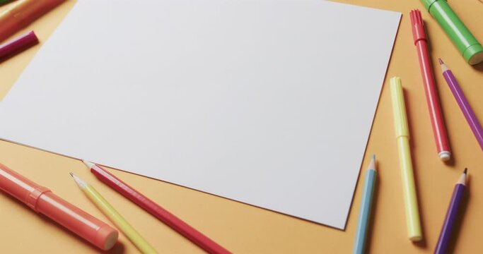 Close up of blank sheet of paper with school stationery on beige background, in slow motion