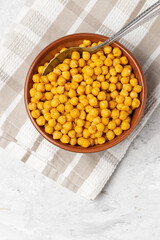 Traditional oriental dish roasted chickpeas with spices in a clay bowl on table napkin top view