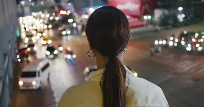 In evening woman gazes at bustling city traffic crowdedness back view close-up. Crowdedness characteristic of modern urban dynamism Crowdedness where futuristic city's pulse is felt.