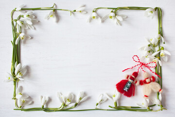 White wooden background with spring flowers snowdrops in the form of a frame and red and white...