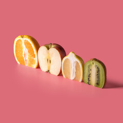 Creative composition with sliced fruits on pink background. Summer minimal concept.