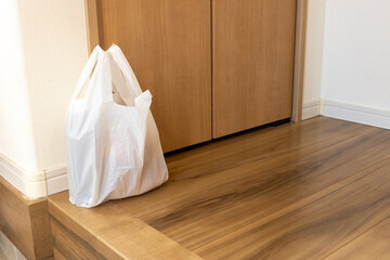 玄関に置かれた食品の入ったレジ袋イメージ