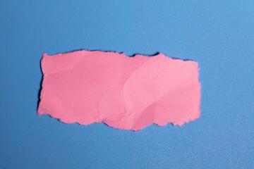torn pink construction paper for use as a banner or button on a blue background