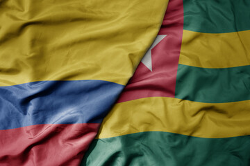 big waving national colorful flag of togo and national flag of colombia .