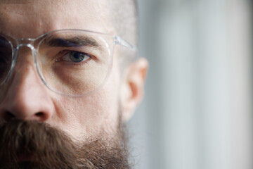 Close-up portrait of a brutal young man in glasses.