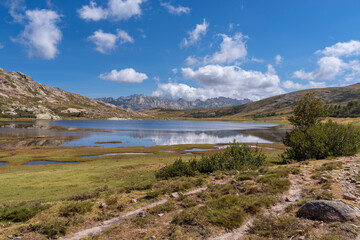 Fototapeta na wymiar Blick über den Lac de Nino mit der Berglandschaft von Restonica im Hintergrund, Korsika, Frankreich