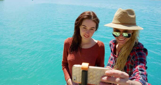 Selfie stick, travel and summer with friends at sea for social media, memory and explore. Smile, adventure and vacation with women and picture in france beach for holiday, spring break and tourism