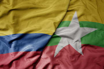 big waving national colorful flag of myanmar and national flag of colombia .