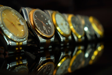 Luxury watches placed on a glittering glass floor.